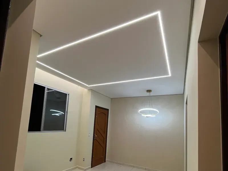 Sala com forro de gesso rebaixado e perfil de LED embutido em linha contínua no teto, obra da Avante Acabamentos em Belo Horizonte